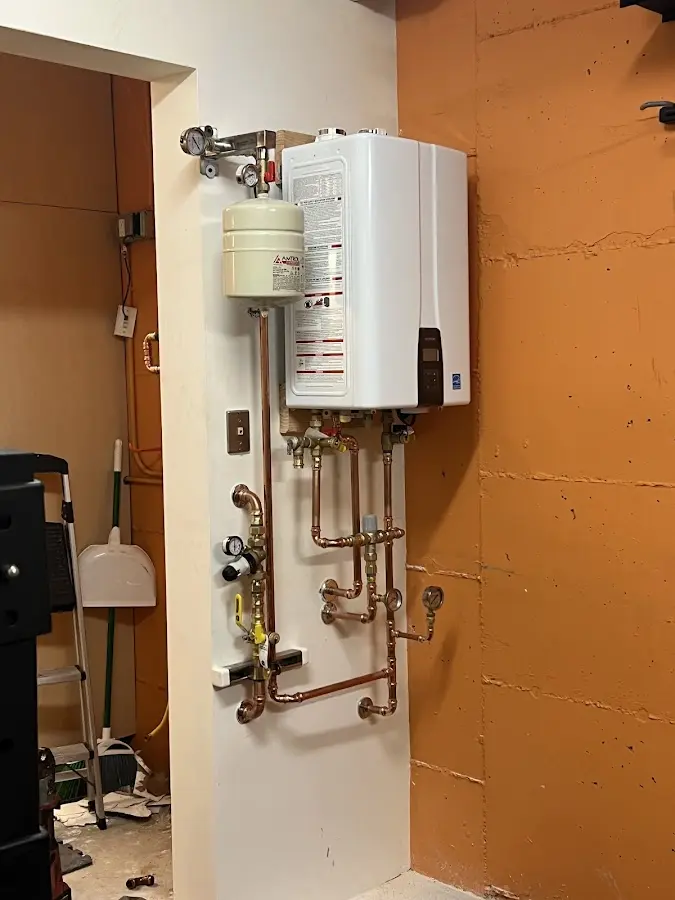 Plumbing technician inspecting water heater connections in Naugatuck